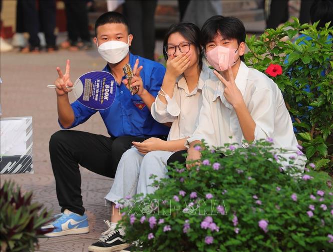 Tình nguyên viên và các thí sinh điểm thi Trường THPT Đan Phượng (Đan Phượng, Hà Nội) trước giờ vào phòng thi. Ảnh: Hoàng Hiếu - TTXVN 